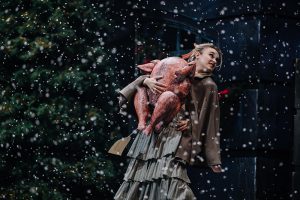 Photograph of performers on stage surrounded by trees.