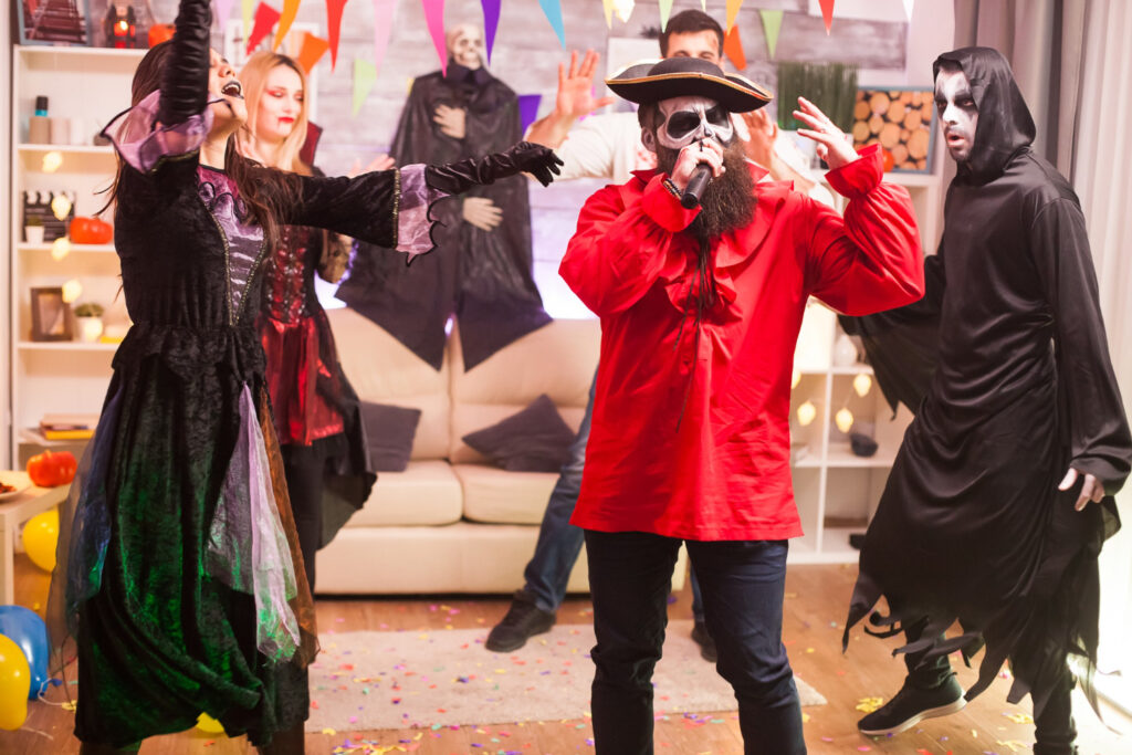 man pirate costume doing karaoke halloween party with his friends